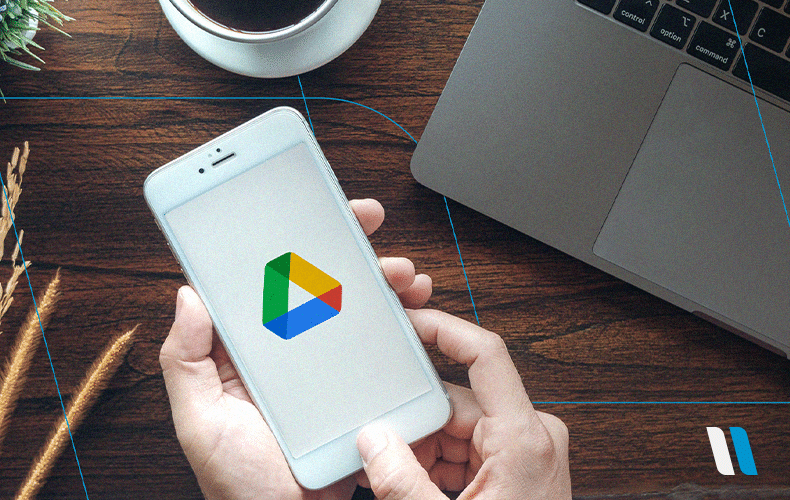 mão segurando um smartphone com o ícone do Google Drive